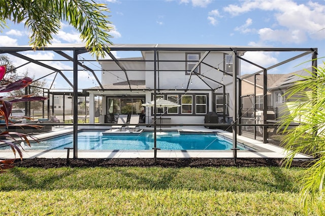 outdoor pool with glass enclosure, a lawn, and a patio