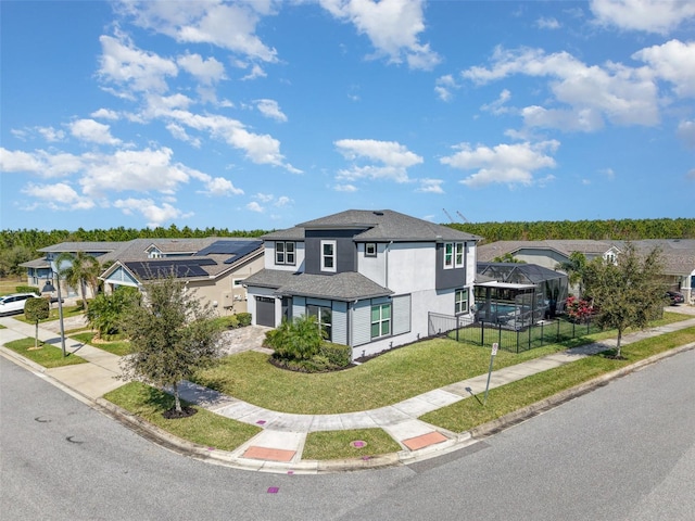 view of front of home with driveway, a garage, glass enclosure, a residential view, and a front lawn