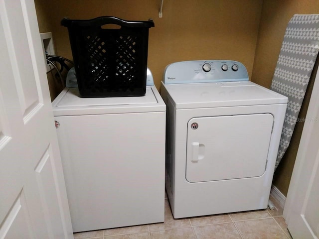 laundry room featuring light tile patterned floors and washer and clothes dryer