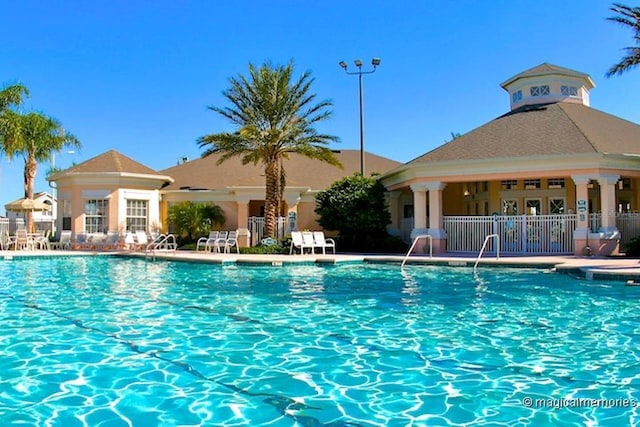 pool with a patio area and fence