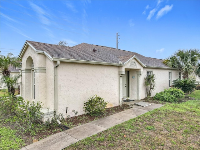 single story home with a shingled roof and stucco siding