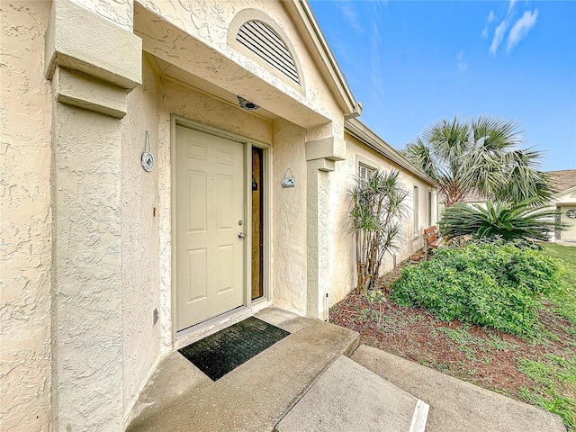 entrance to property featuring stucco siding