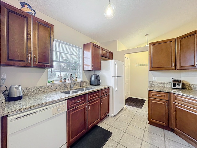 kitchen featuring lofted ceiling, light tile patterned floors, light stone counters, white appliances, and a sink