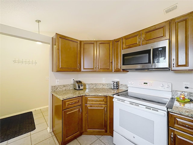 kitchen with brown cabinetry, white range with electric cooktop, stainless steel microwave, and visible vents