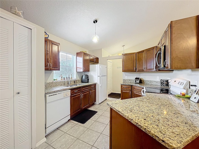 kitchen with a textured ceiling, light tile patterned flooring, white appliances, a sink, and hanging light fixtures