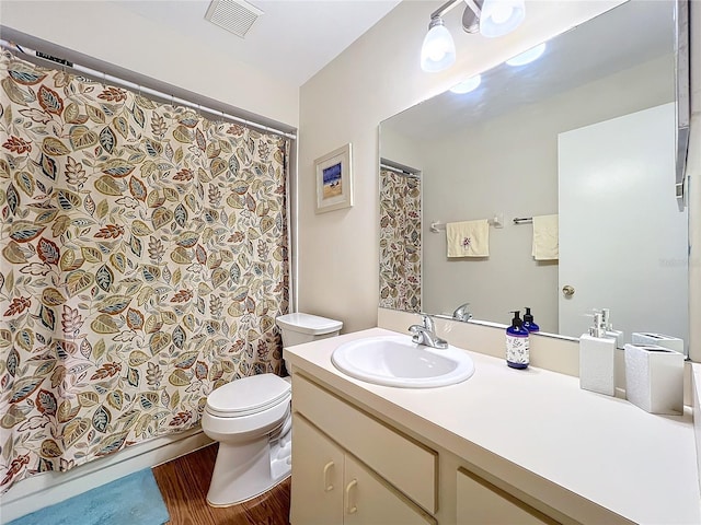 bathroom featuring toilet, visible vents, wood finished floors, and vanity