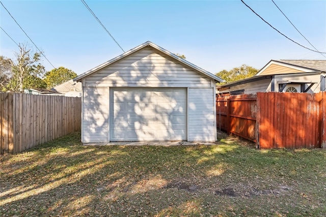 detached garage featuring driveway and fence