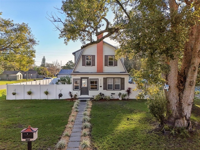 colonial inspired home featuring fence, a front lawn, and a gambrel roof