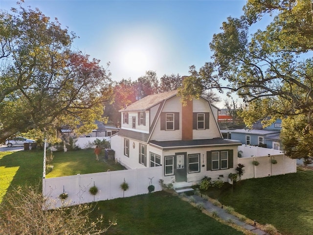 view of front of home featuring a front lawn, fence private yard, and a gambrel roof