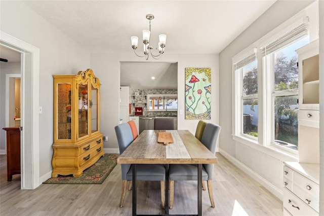 dining area with an inviting chandelier, baseboards, and light wood finished floors