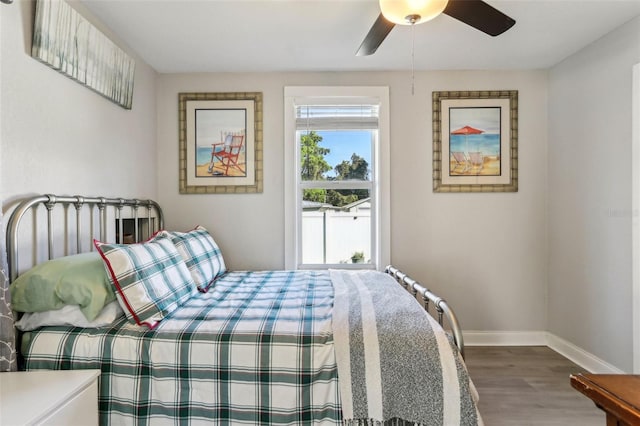 bedroom with ceiling fan, baseboards, and wood finished floors