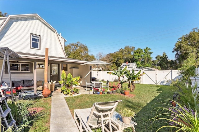 rear view of house with a lawn, a patio area, a fenced backyard, and a gate