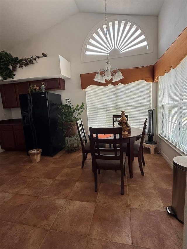 dining space featuring high vaulted ceiling and an inviting chandelier