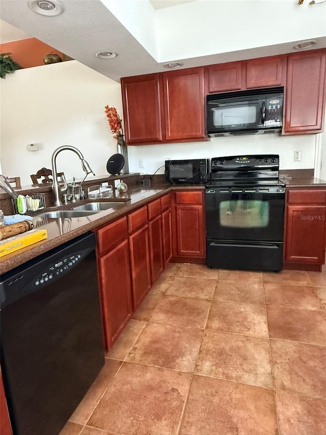 kitchen with reddish brown cabinets, dark countertops, a sink, and black appliances