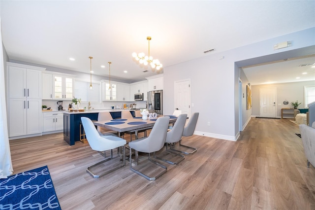 dining space featuring a chandelier, recessed lighting, visible vents, baseboards, and light wood finished floors