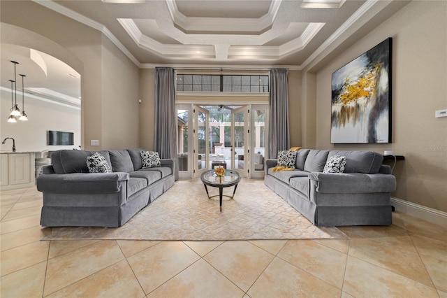 living area with arched walkways, ornamental molding, and light tile patterned flooring