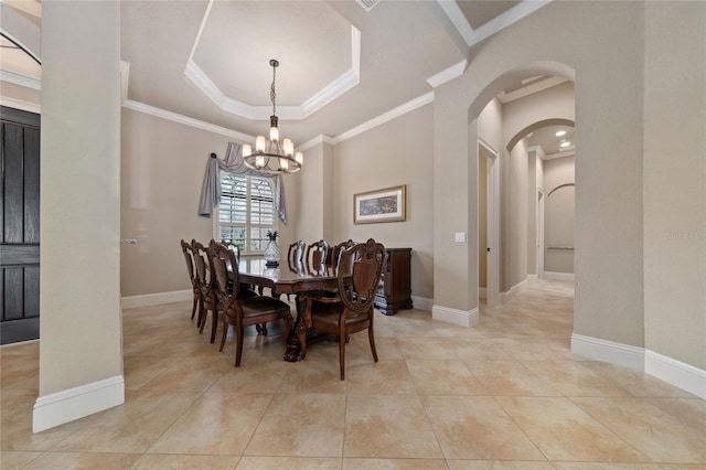 dining room featuring arched walkways, light tile patterned floors, a raised ceiling, ornamental molding, and baseboards