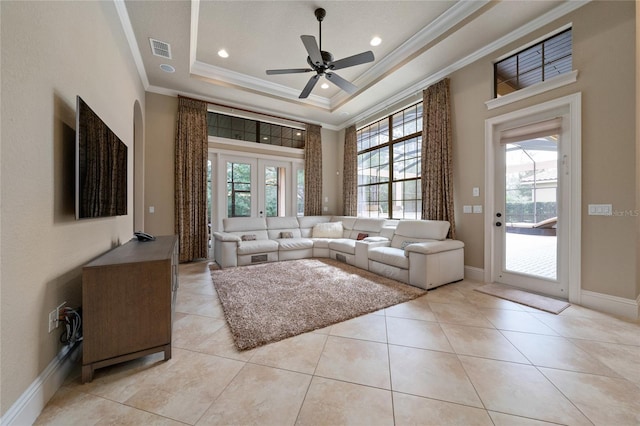 unfurnished living room featuring light tile patterned floors, visible vents, a tray ceiling, and ornamental molding