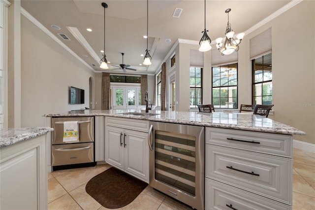 kitchen featuring beverage cooler, a sink, visible vents, and white cabinets