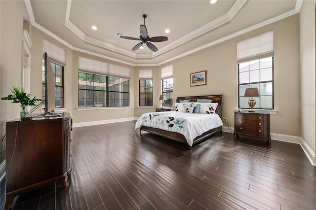 bedroom with ornamental molding, a tray ceiling, dark wood-style flooring, and baseboards