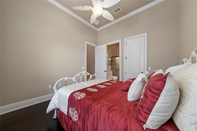 bedroom with ensuite bathroom, dark wood-type flooring, visible vents, baseboards, and crown molding