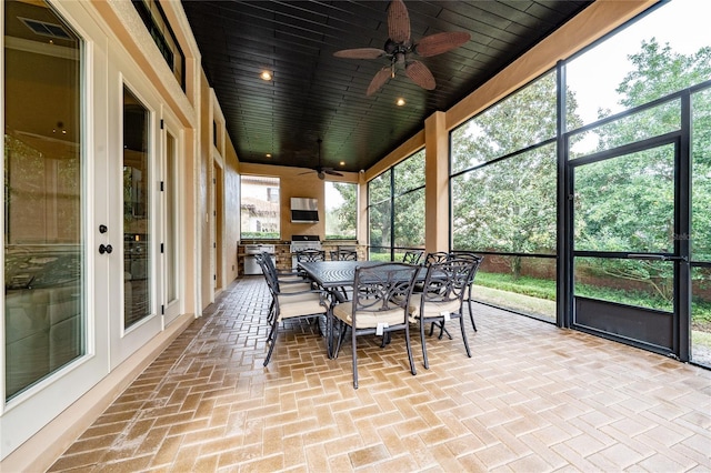 sunroom / solarium featuring wood ceiling and a ceiling fan