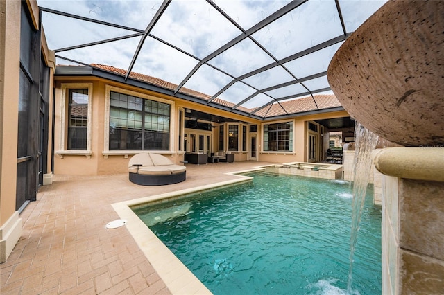 view of swimming pool with a patio area, glass enclosure, and a pool with connected hot tub