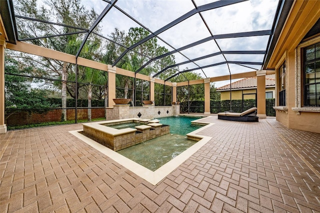 view of pool with glass enclosure, a pool with connected hot tub, and a patio area