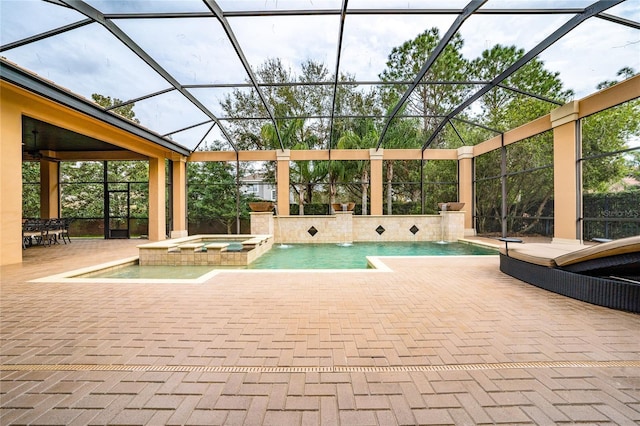 view of swimming pool featuring a pool with connected hot tub, a patio, and a lanai