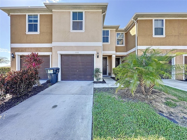 view of front of home with a garage, concrete driveway, and stucco siding