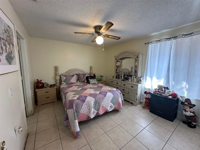 bedroom featuring a textured ceiling, light tile patterned flooring, and a ceiling fan