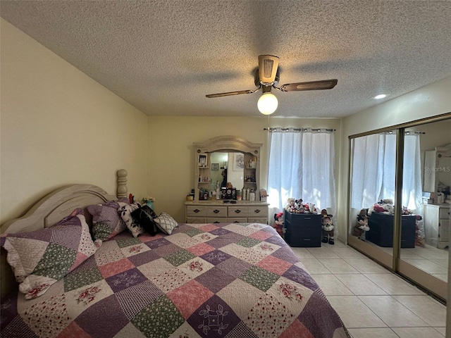 bedroom with light tile patterned floors, a textured ceiling, and a ceiling fan