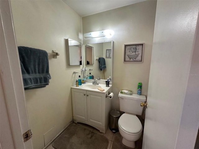 bathroom featuring toilet, tile patterned floors, and vanity