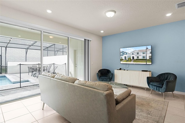 living area with light tile patterned floors, visible vents, radiator heating unit, a sunroom, and a textured ceiling