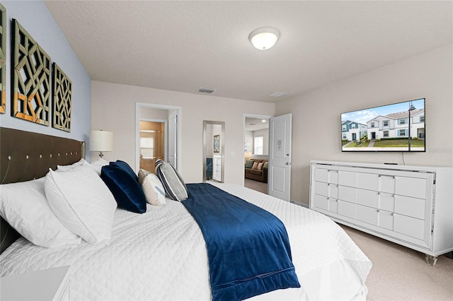 carpeted bedroom with visible vents and a textured ceiling