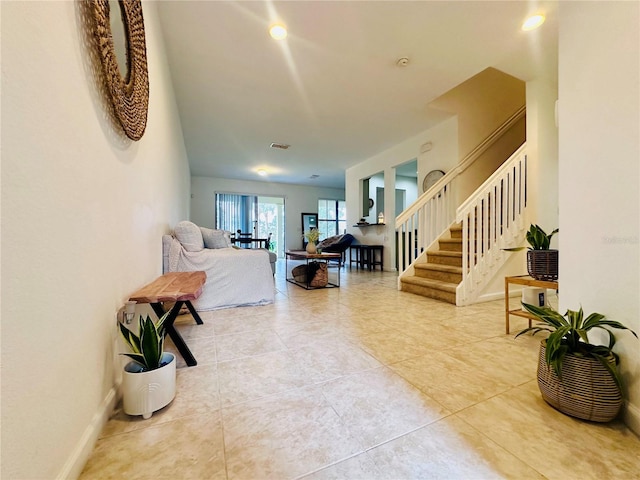 interior space with tile patterned flooring, visible vents, baseboards, and stairs