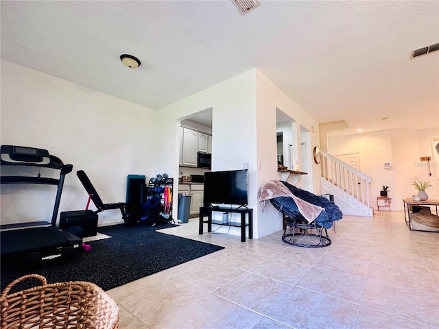 workout area featuring visible vents and light tile patterned flooring