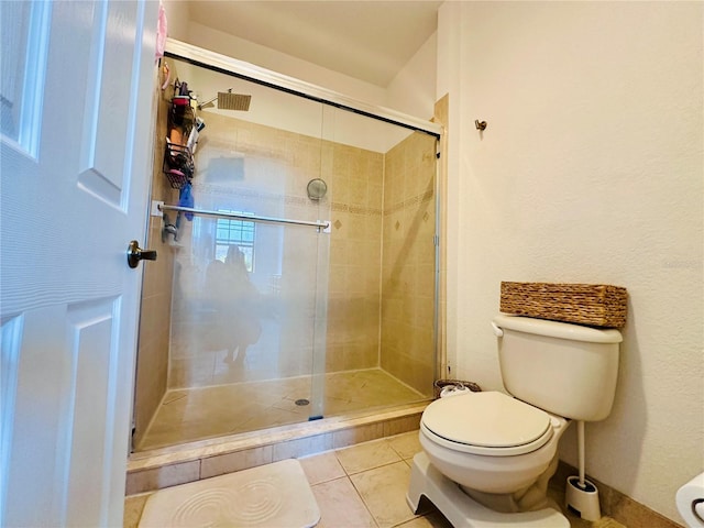 full bath with a stall shower, toilet, and tile patterned floors