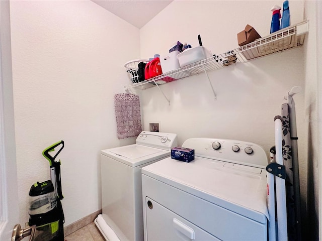 laundry area with washing machine and dryer, laundry area, baseboards, and light tile patterned floors