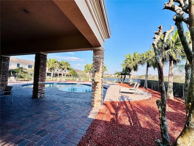 community pool with a patio and fence