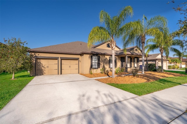 view of front of home featuring an attached garage, driveway, a front lawn, and stucco siding