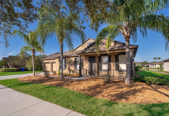 view of front of house featuring a front lawn, concrete driveway, an attached garage, and stucco siding