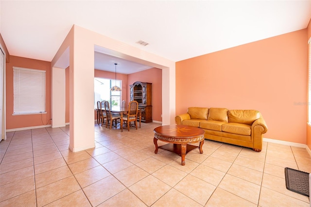 living room featuring light tile patterned floors, visible vents, and baseboards