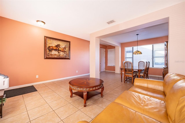 living room featuring light tile patterned floors, visible vents, and baseboards