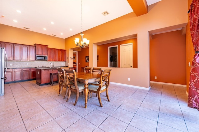 dining space with light tile patterned floors, baseboards, visible vents, and an inviting chandelier