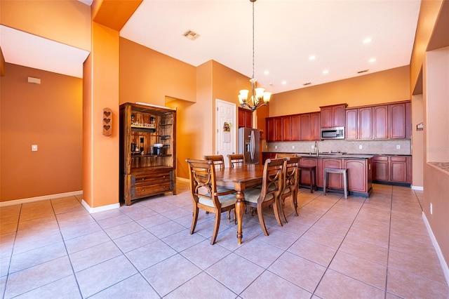 dining space with baseboards, visible vents, a chandelier, and light tile patterned flooring