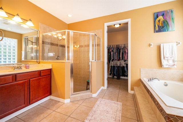 full bath featuring a stall shower, tile patterned flooring, vanity, and a bath