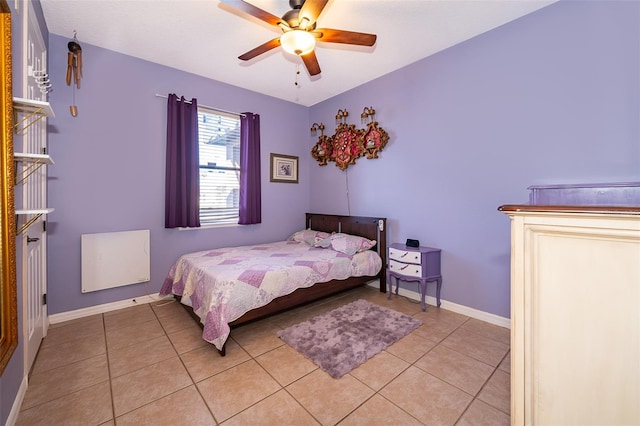 bedroom with light tile patterned flooring, a ceiling fan, and baseboards