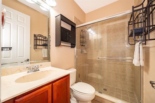 bathroom featuring a stall shower, vanity, and toilet