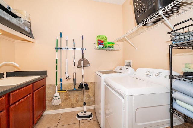 laundry area featuring washer and dryer, a sink, and light tile patterned floors